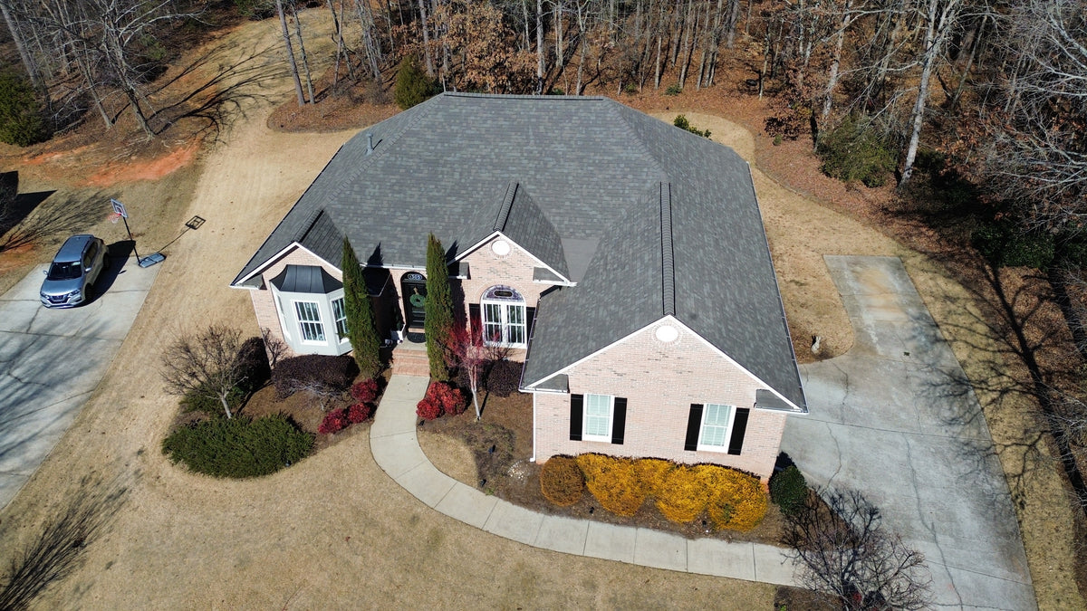 Aerial view of a brick home with a new gray shingle roof